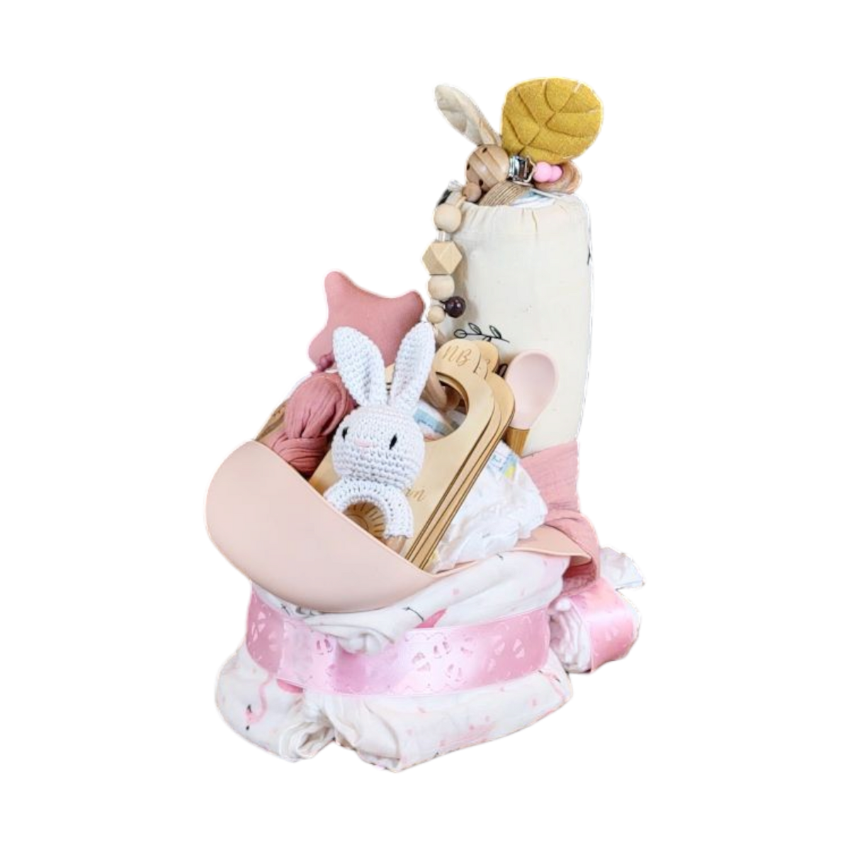 Das Hello World Windelgeschenk Lama (35x19cm) enthält einen rosafarbenen Schnuller, ein gehäkeltes Häschen, eine Holzrassel, Beißperlen und Babyartikel, die mit einem rosafarbenen Band und weißen Windeln wie eine hübsche Windeltorte angeordnet sind.
