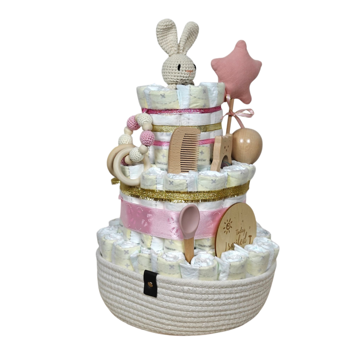 Die Hello World Windeltorte Hase [25x42cm] ist liebevoll mit pinken Bändern, Häschengurke, Zauberstab, Holzspielzeug und nachhaltigen Babygeschenken im weißen Geschenkkorb - das perfekte Geschenk zur Geburt.