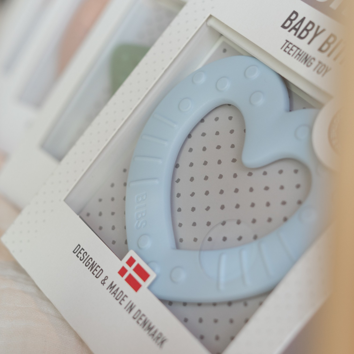 Hellblauer Herz-Beissring in Produktverpackung, entwickelt und hergestellt in Dänemark