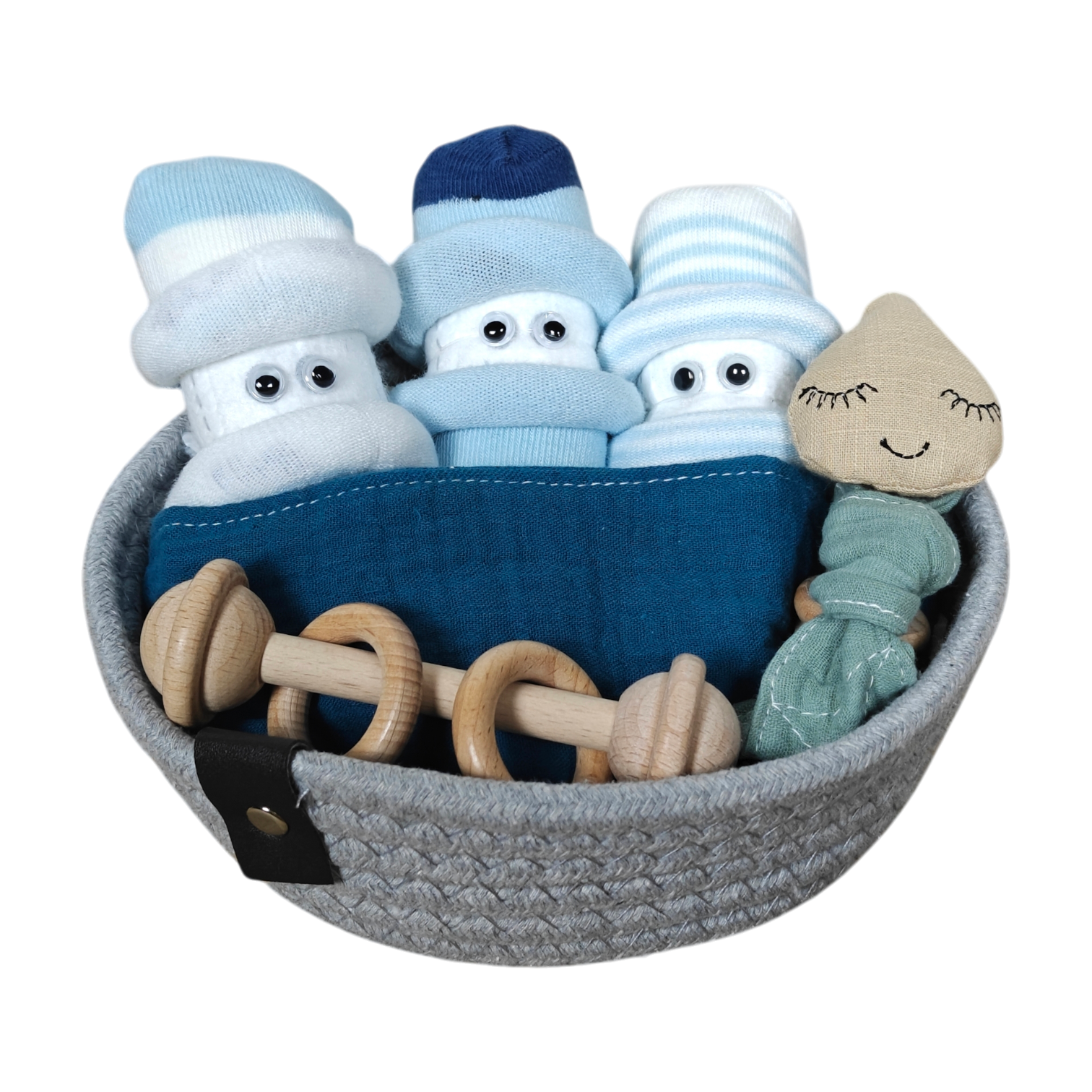 Das Kuschelkörbchen Regentropfen von Hello World enthält drei Paar Babysocken, die wie gewickelte Babys mit Mützen und Kulleraugen gerollt sind, sowie eine Holzrassel und eine Stoffpuppe - ein bezauberndes Geschenk zur Geburt.