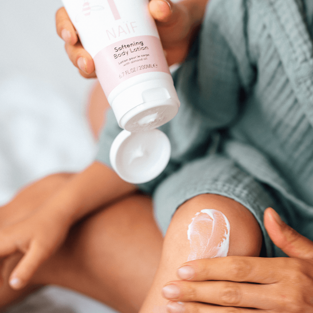 Naïf Baby & Kids Lotion Corps 200 ml lors de l'application de la crème sur la peau sensible des enfants après le bain.