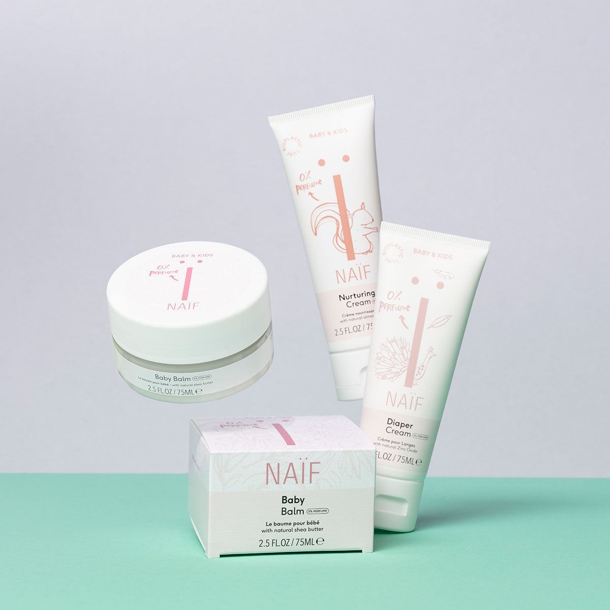 Kind hält die parfümfreie Naïf Baby & Kids Windelcreme 75 ml während der täglichen Babypflege in der Hand.