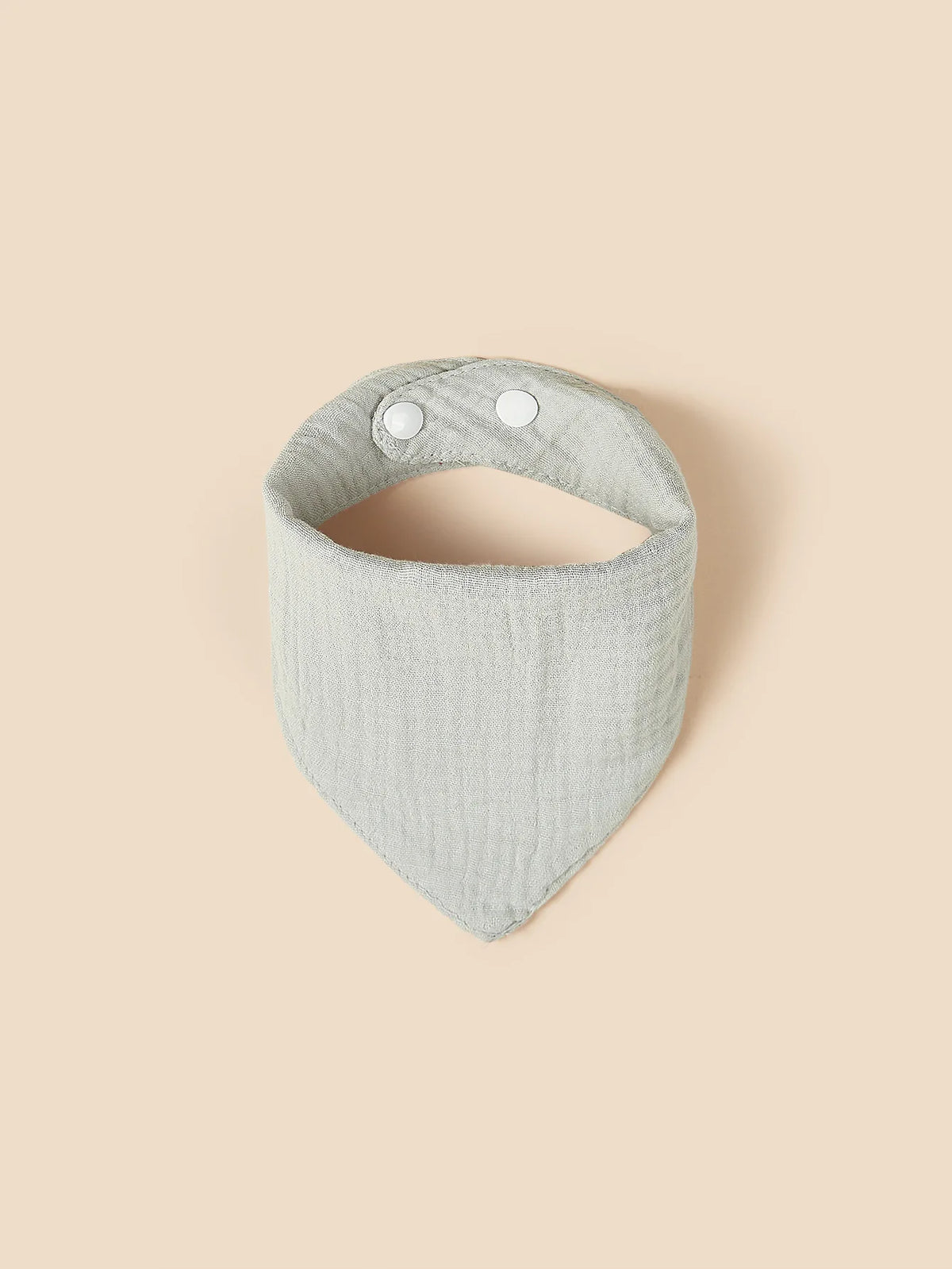 Un bavaglino triangolare in cotone azzurro di Hello World con due bottoni automatici bianchi, mostrati su uno sfondo beige.