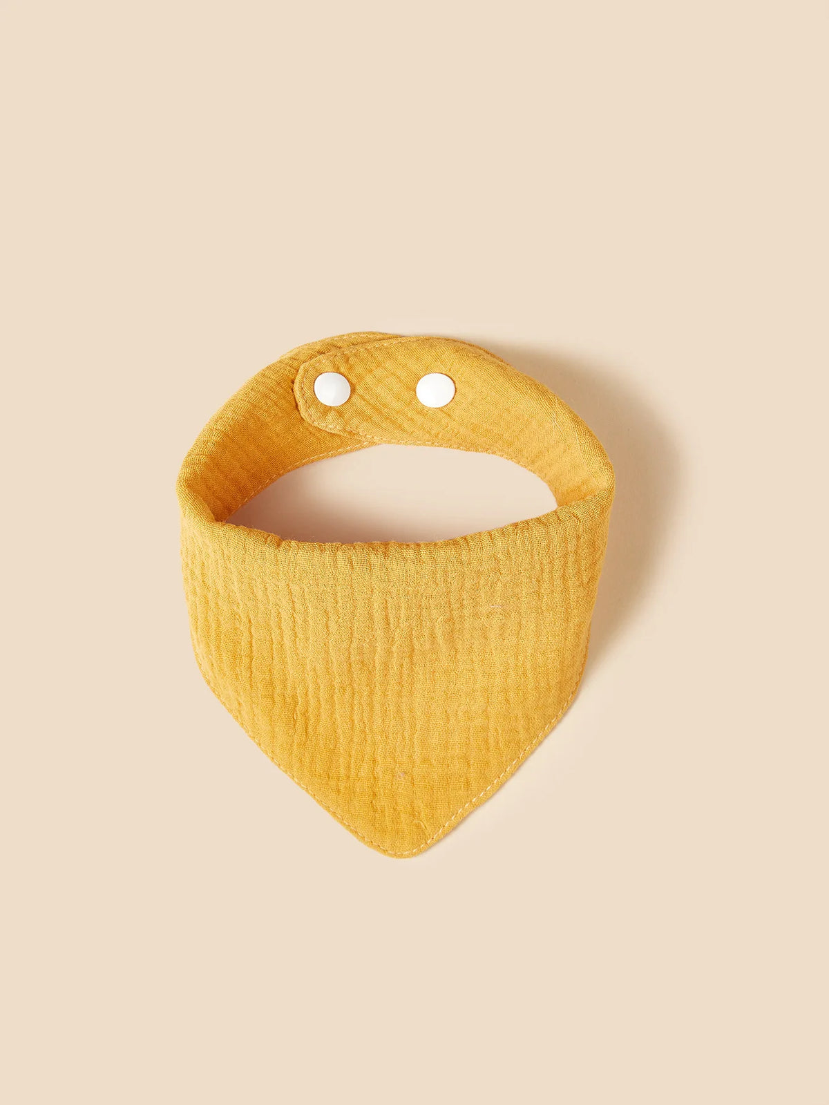 Il bavaglino in cotone giallo Hello World è un bavaglino giallo strutturato in stile bandana con due bottoni automatici bianchi. È realizzato in morbido cotone e mostrato su uno sfondo beige neutro.