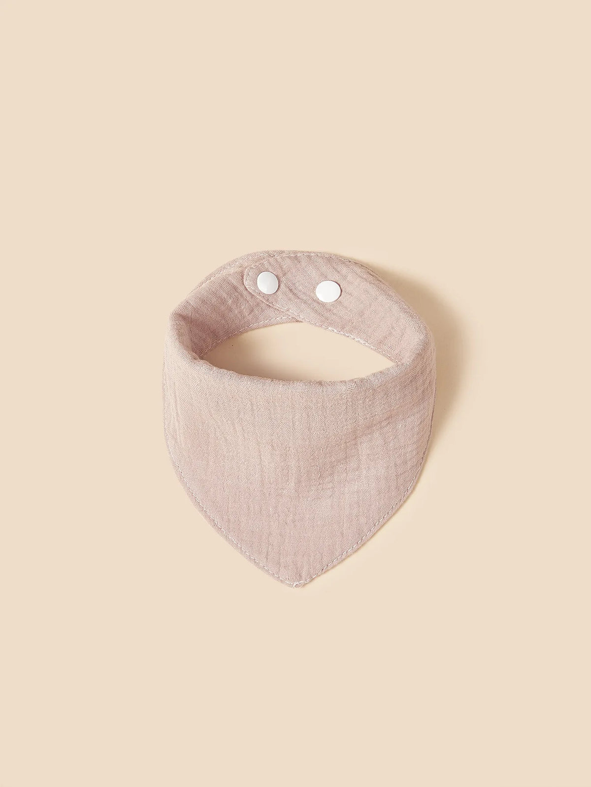 Der Hello World Latz aus Baumwolle Hellrosa ist ein hellrosa, dreieckiges Lätzchen mit zwei weißen Druckknöpfen auf einem beigen Hintergrund - weich und stilvoll für Babys.