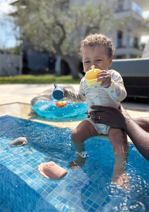 Child plays with the Small Foot silicone bath toy set in the pool with the four squirting animals.