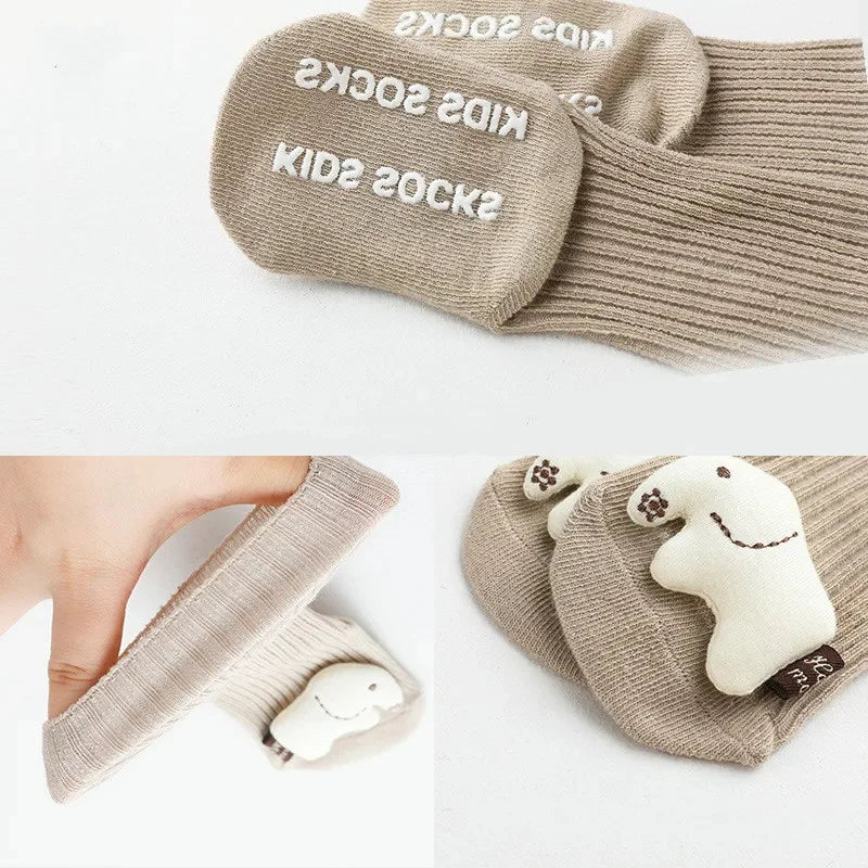 Beige, handgefertigte Hello World Socken Elefant (Sohle: 6,5x9cm) für 0-6 Monate mit weißem "KIDS SOCKS"-Text auf der Sohle und niedlichem, weißem Elefanten-Design auf den Zehen. Nahaufnahme und Seitenansicht abgebildet.