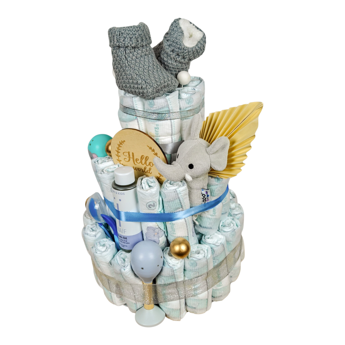 Side view of Andrin diaper cake in gray and blue with knitted baby booties, elephant, bath oil and baby accessories.