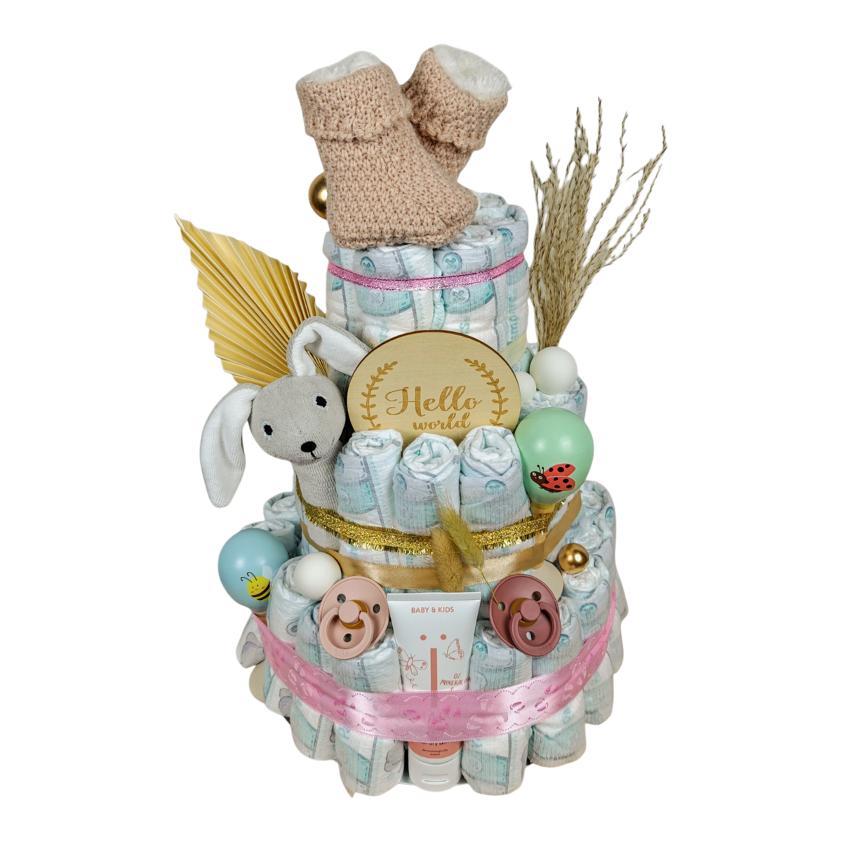 Seitliche Ansicht der Windeltorte Elaia mit Hasenrassel, BIBS Schnullern, NAÏF Pflegecreme und liebevollen Rosa- und Naturdetails