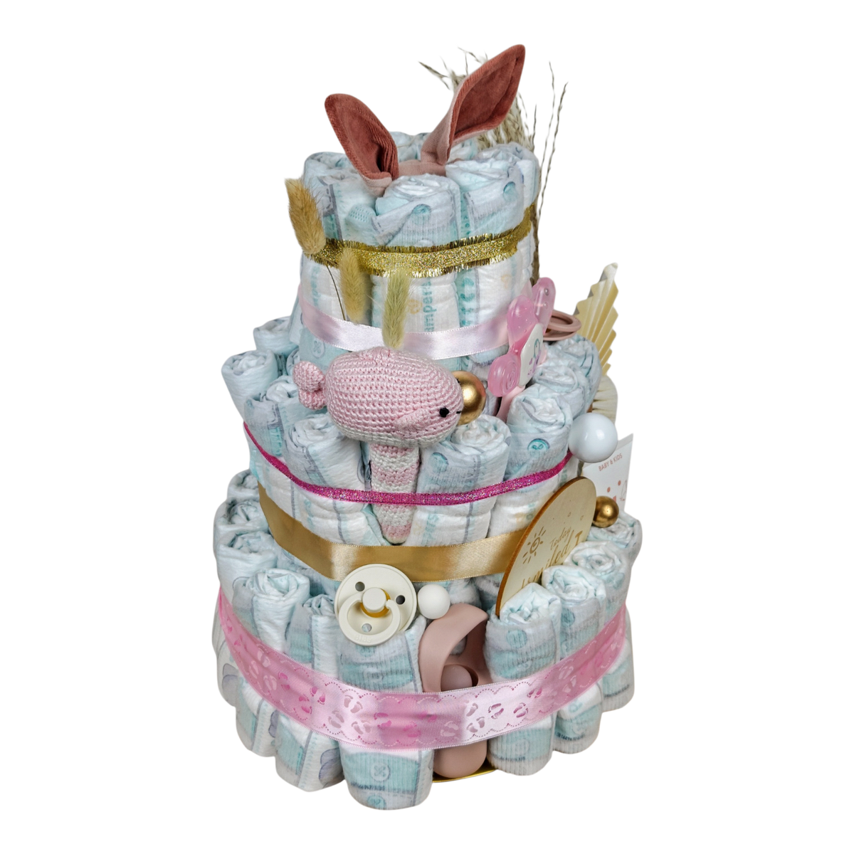 Seitenansicht der Windeltorte Elina mit gehäkelter Babyrassel Walfisch hellrosa, BIBS Fruchtsauger und Babybürste